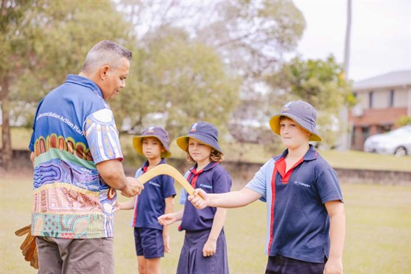 Ngutana Lui Cultural tutor handing students a boomerang