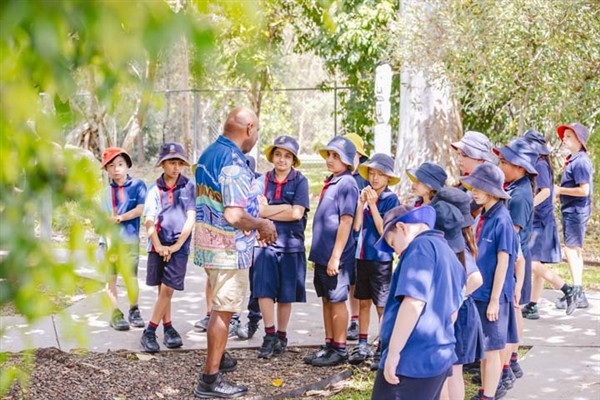 Cultural Tutor Brian Whap with a group of students on a nature walk