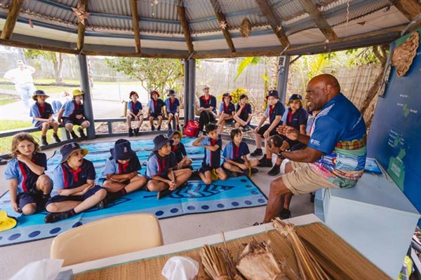 Students sitting under the pergola listening to Torres Strait Island Tutor, Brian Whap