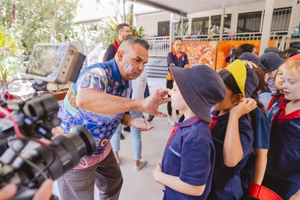 Cultural Tutor Marlon Riley painting students faces