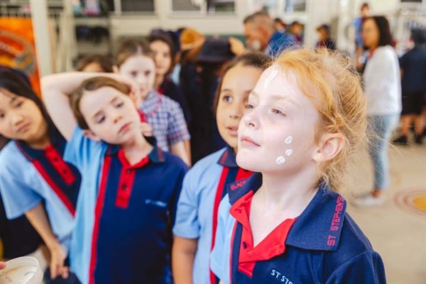School students lining up to have their face painted