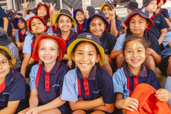 School students smiling listening to a Tutor